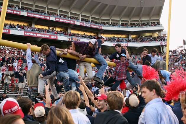 OXFORD, MS - OCTOBER 4: Fans of the Ole Miss Rebels hang on the goalpost while celebrating the victory over the Alabama Crimson Tide on OCTOBER 4, 2014 at Vaught-Hemingway Stadium in Oxford, Mississippi. Mississippi beat Alabama 23-17. (Photo by Joe Murphy/Getty Images)