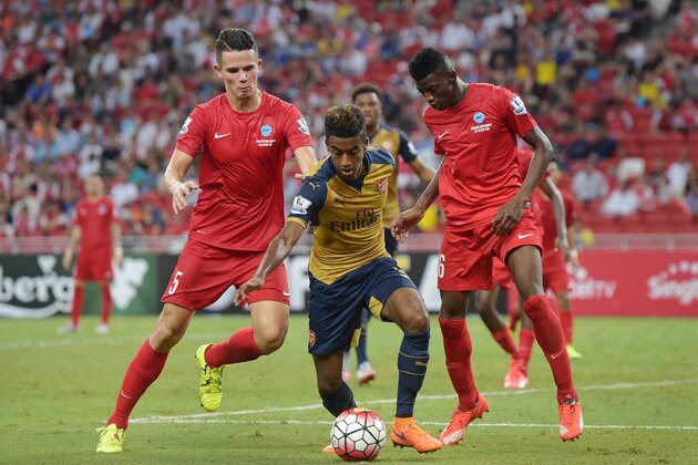 Arsenal midfielder Gedion Zelalem, center, vies for the ball with Singapore Selection's Baihakki Khaizan, left, and Sirina Camara, right, during their soccer match for the Barclays Asia Trophy in Singapore, Wednesday, July 15, 2015.(AP Photo/Joseph Nair)