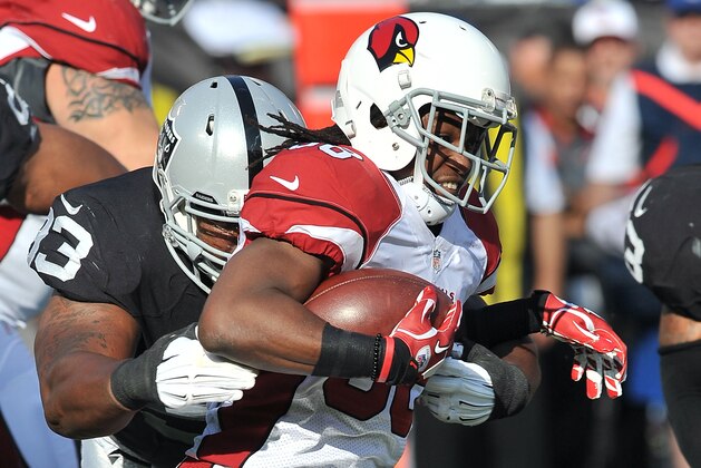 Arizona Cardinals running back (38) Andre Ellington tries to get away from Oakland Raiders defensive tackle (93) Rickey Lumpkin during a preseason game played at O.co Coliseum in Oakland on Sunday, Aug. 30, 2015. (AP Photo/John Cordes)