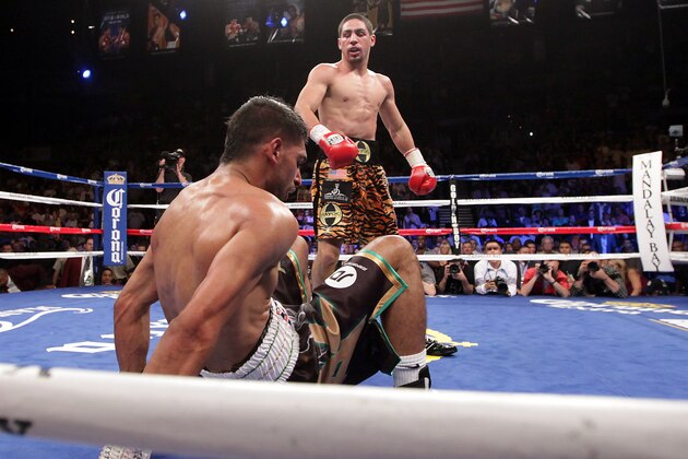 Danny Garcia (top) from Philadelphia, Pennsylvania, stands over Amir Khan, from Bolton, England after knocking him to the canvas in the third round on July 14, 2012 at the Mandalay Bay Events Center in Las Vegas, Nevada.  Garcia defeated Khan with a TKO in the fourth round, claiming the WBC and WBA super lightweight titles and the vacant Ring Magazine Jr. welterweight title.  AFP PHOTO / John GURZINSKI        (Photo credit should read JOHN GURZINSKI/AFP/GettyImages)