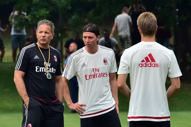 AC Milan's Serbian head coach Sinisa Mihajlovic (L), flanked by AC Milan's Italian midfielder Riccardo Montolivo (C), oversees his first training session at AC Milan's Milanello training centre in Milan on July 3, 2015. AFP PHOTO / GIUSEPPE CACACE        (Photo credit should read GIUSEPPE CACACE/AFP/Getty Images)