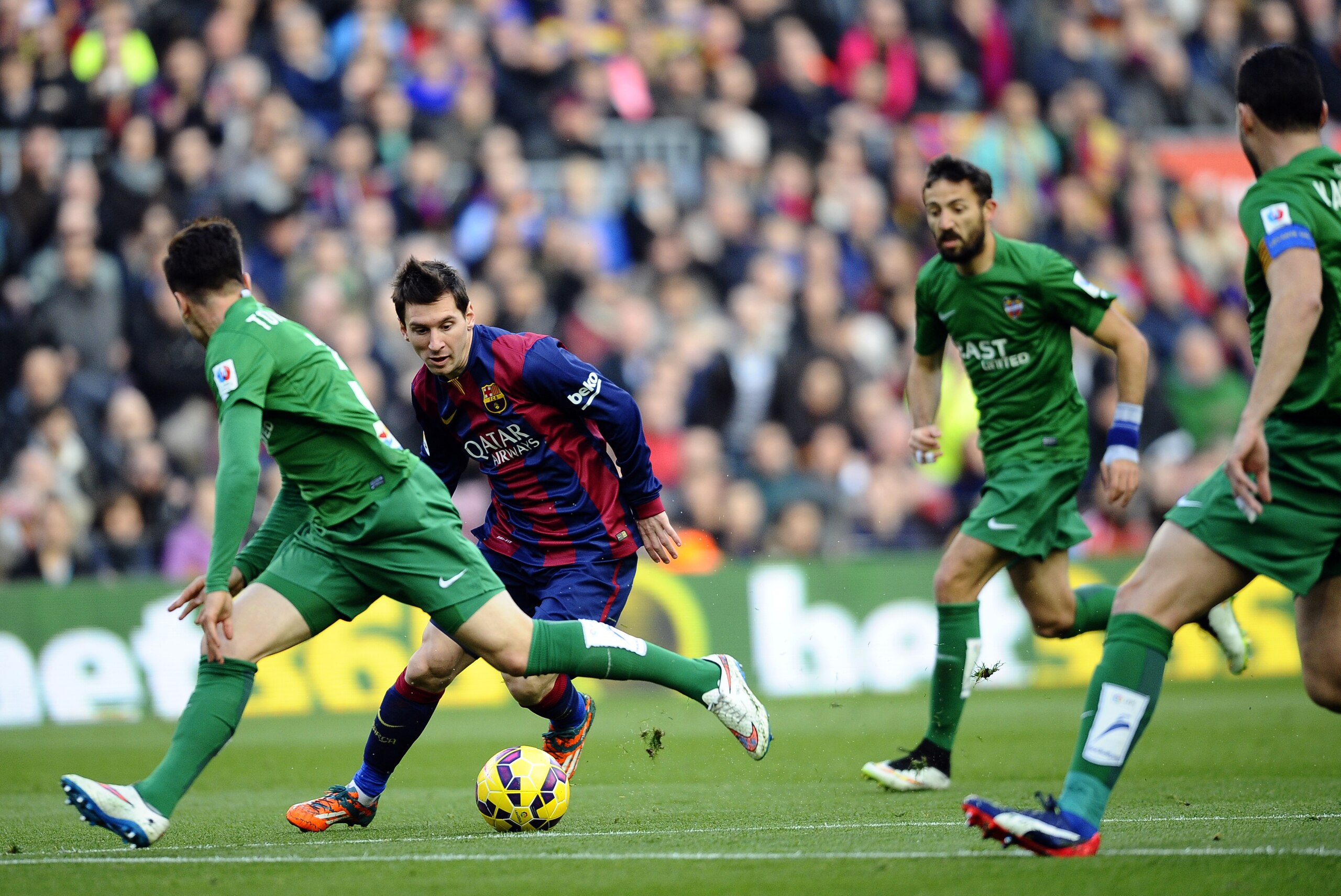 FC Barcelona's Lionel Messi, from Argentina, second left, controls the ball against Levante's Tono Garcia, left, during a Spanish La Liga soccer match at the Camp Nou stadium in Barcelona, Spain, Sunday, Feb. 15, 2015. (AP Photo/Manu Fernandez)