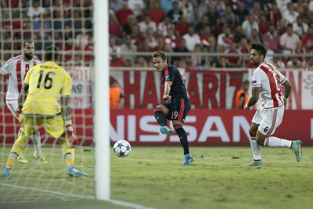 Bayern's Mario Gotze, center, shoots to score the second goal for his team past Olympiakos' goalkeeper Roberto during a Champions League Group F soccer match between Olympiakos and Bayern Munich at Georgios Karaiskakis stadium in Piraeus port, near Athens, Wednesday, Sept. 16, 2015. (AP Photo/Petros Giannakouris)