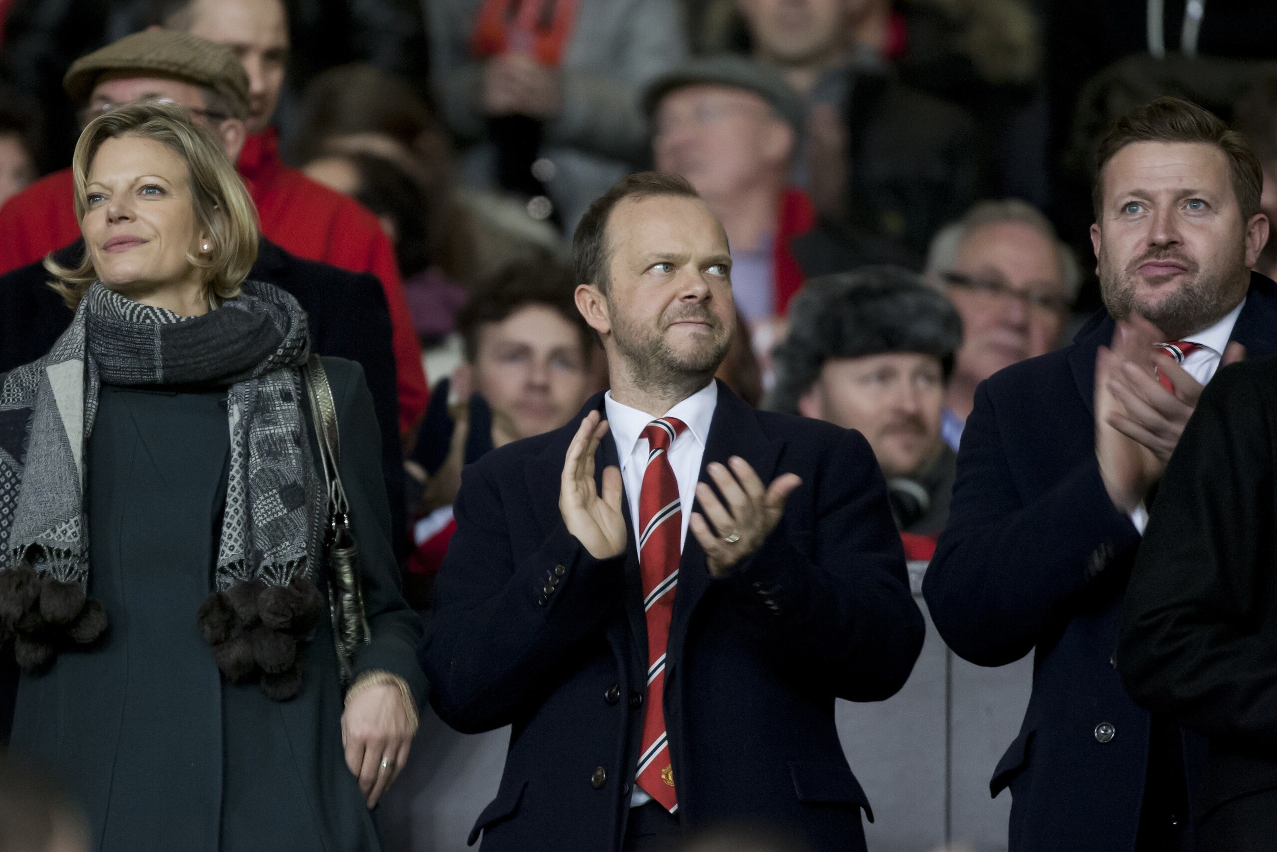 Manchester United chief executive Ed Woodward, centre, applauds before the team's English Premier League soccer match against Tottenham at Old Trafford Stadium, Manchester, England, Wednesday Jan. 1, 2014. (AP Photo/Jon Super)