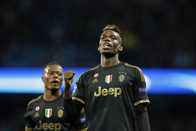 Juventus' Paul Pogba, right, and Patrice Evra celebrate after the Champions League group D soccer match between Manchester City and Juventus at the Etihad Stadium, Manchester, England, Tuesday, Sept. 15, 2015. Juventus won the match 2-1. (AP Photo/Jon Super)