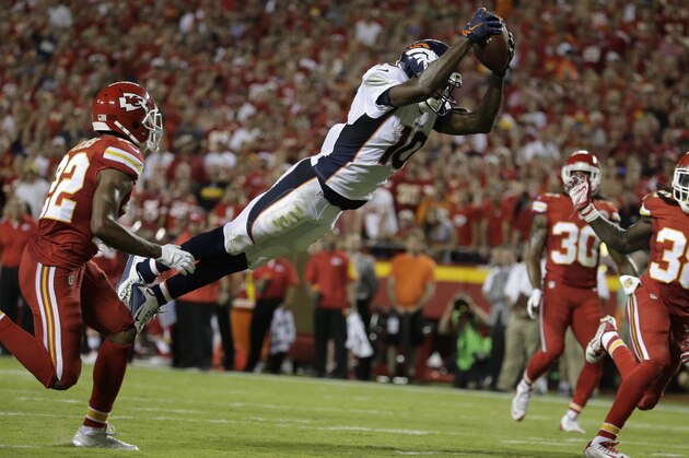 Denver Broncos wide receiver Emmanuel Sanders (10) leaps for a touchdown between Kansas City Chiefs defensive backs Marcus Peters, left, Jamell Fleming (30) and Ron Parker (38) during the first half of an NFL football game in Kansas City, Mo., Thursday, Sept. 17, 2015. (AP Photo/Charlie Riedel)