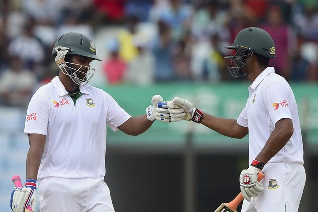 Bangladesh cricketer Tamim Iqbal (L) celebrates his half century (50 runs) with teammate Mohammad Mahmudullah (R) during the second day of the first cricket Test match between Bangladesh and South Africa at the Zahur Ahmed Chowdhury Stadium in Chittagong on July 22, 2015. AFP PHOTO/ Munir uz ZAMAN        (Photo credit should read MUNIR UZ ZAMAN/AFP/Getty Images)