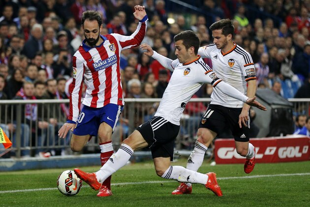 Atletico de Madrid’s Juan Fran, left, duels for the ball with Valencia's Jose Gaya during a Spanish La Liga soccer match between Atletico de Madrid and Valencia at the Vicente Calderon stadium in Madrid, Spain, Sunday, March 8, 2015. (AP Photo/Daniel Ochoa de Olza)