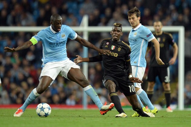 Manchester City's Ivorian midfielder Yaya Toure (L) vies with Juventus' midfielder from France Paul Pogba during a UEFA Champions League group stage football match between Manchester City and Juventus at the Etihad stadium in Manchester, north-west England on September 15, 2015.      AFP PHOTO / OLI SCARFF        (Photo credit should read OLI SCARFF/AFP/Getty Images)