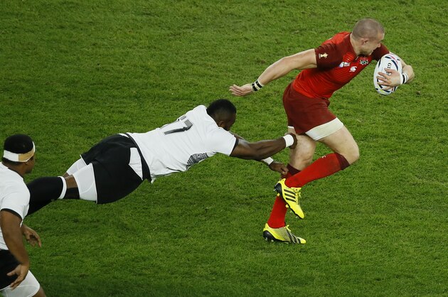 England's Mike Brown is tackled by Fiji's Peni Ravai, centre, during the Rugby World Cup Pool A match between England and Fiji at Twickenham Stadium, London, Friday, Sept. 18, 2015. (AP Photo/Kirsty Wigglesworth)