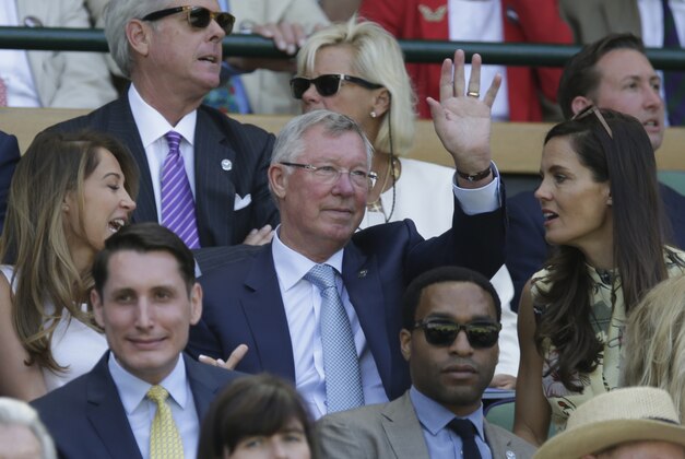 Former soccer manager Alex Ferguson waves in the Royal Box of Centre Court, ahead of the men's singles semifinal matches,  at the All England Lawn Tennis Championships in Wimbledon, London, Friday July 10, 2015. (AP Photo/Pavel Golovkin)
