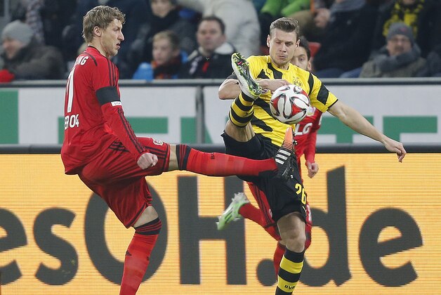 Leverkusen's Stefan Kießling, left, and Dortmund's Lukasz Piszczek challenge for the ball during the German first division Bundesliga soccer match between Bayer 04 Leverkusen and BvB Borussia Dortmund in Leverkusen, Germany, Saturday, Jan. 31, 2015. (AP Photo/Frank Augstein)