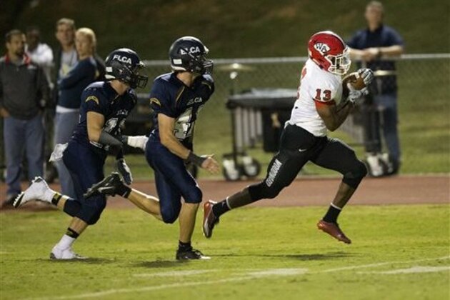 FILE - In this Sept. 26, 2014, file photo, Woodward Academy running back Elijah Holyfield runs for a touchdown after catching a pass against Eagle's Landing Christian Academy in the first half of a high school football game in Stockbridge, Ga. Holyfield, the top-rated running back in the state of Georgia and the son of former boxing champion Evander Holyfield, says he will sign with Georgia. Holyfield announced his decision on Friday, Sept. 4, 2015.(AP Photo/John Bazemore, File)