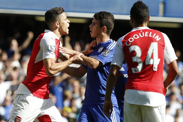 Chelsea's Oscar, centre, holds back Arsenal's Gabriel who had been show a red card for a second clash with Chelsea's Diego Costa after during the English Premier League soccer match between Chelsea and Arsenal at Stamford Bridge stadium in London, Saturday, Sept. 19, 2015. Chelsea won the game 2-0.(AP Photo/Alastair Grant) Chelsea's Oscar, centre, holds back Arsenal's Gabriel who had been show a red card for a second clash with Chelsea's Diego Costa after during the English Premier League soccer match between Chelsea and Arsenal at Stamford Bridge stadium in London, Saturday, Sept. 19, 2015. Chelsea won the game 2-0.(AP Photo/Alastair Grant)