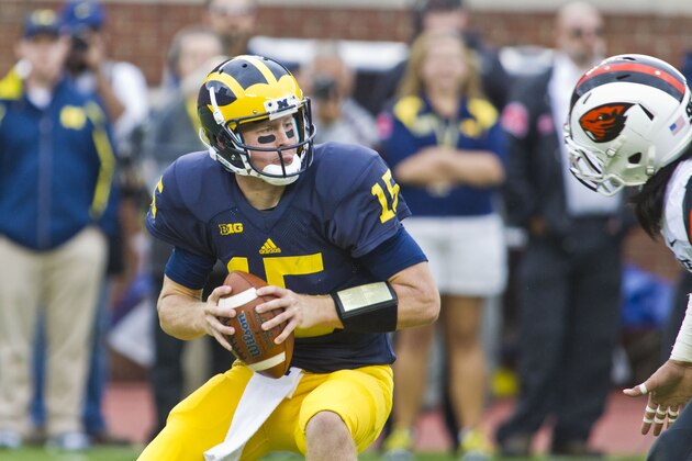Michigan quarterback Jake Rudock (15) handles the ball trying to evade tackles in the third quarter of an NCAA college football game against Oregon State in Ann Arbor, Mich., Saturday, Sept. 12, 2015. Michigan won 35-7. (AP Photo/Tony Ding)