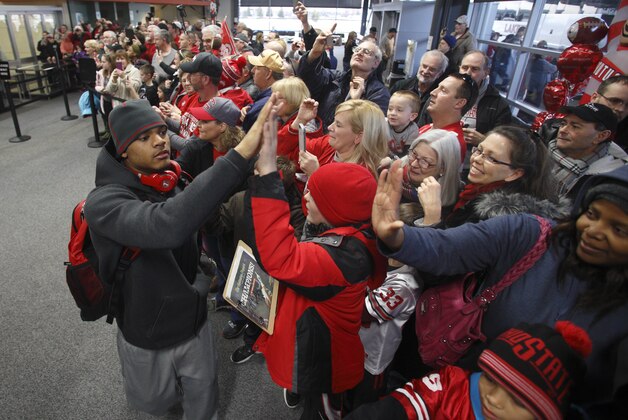 Ohio State corner back Damon Webb left, greets fans as he and his teammates arrive at Rickenbacker International Airport in Groveport, Ohio, Tuesday, Jan. 13, 2015, following a National Championship win over Oregon in Dallas, Texas. (AP Photo/Paul Vernon)