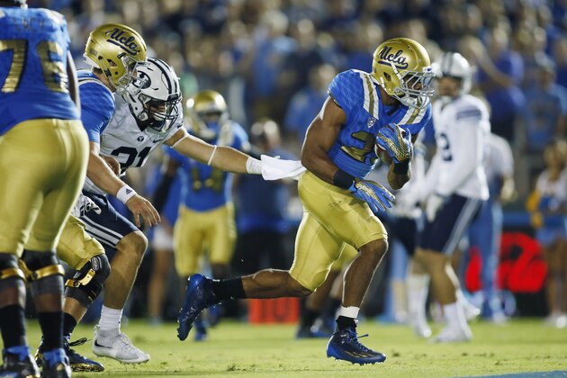 UCLA running back Nate Starks scores a touchdown past BYU linebacker Sae Tautu  during the the fourth quarter of an NCAA college football game, Saturday, Sept. 19, 2015, in Pasadena, Calif. UCLA won 24-23. (AP Photo/Danny Moloshok)