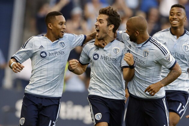 Sporting Kansas City midfielder Benny Feilhaber (10) celebrates his goal with teammates Amadou Dia (13) and Kevin Ellis (4) during the first half of an MLS soccer match against the Montreal Impact in Kansas City, Kan., Saturday, July 18, 2015. Sporting KC defeated the Montreal Impact 2-1. (AP Photo/Orlin Wagner)