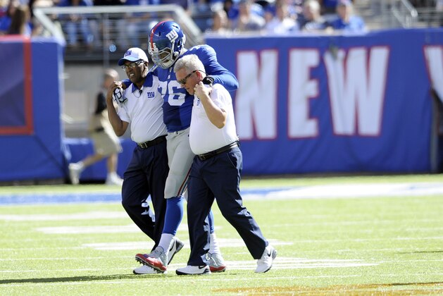 New York Giants offensive tackle Ereck Flowers is helped off the field during the second half of an NFL football game against the Atlanta Falcons, Sunday, Sept. 20, 2015, in East Rutherford, N.J. (AP Photo/Bill Kostroun)