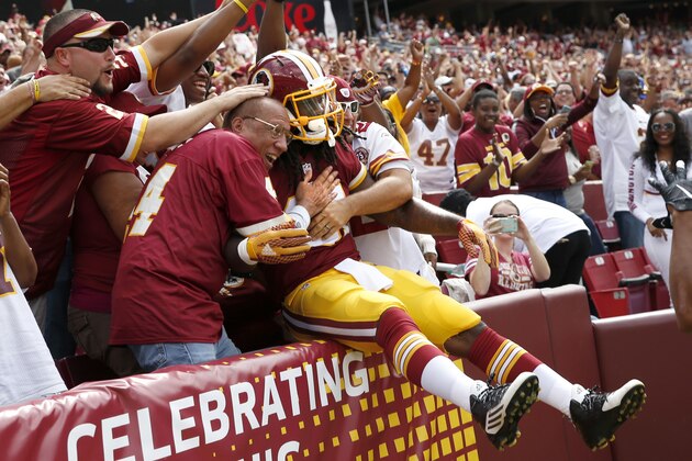 Washington Redskins running back Matt Jones jumps into the fans after scoring a touchdown during the first half of an NFL football game against the St. Louis Rams in Landover, Md., Sunday, Sept. 20, 2015. (AP Photo/Alex Brandon)