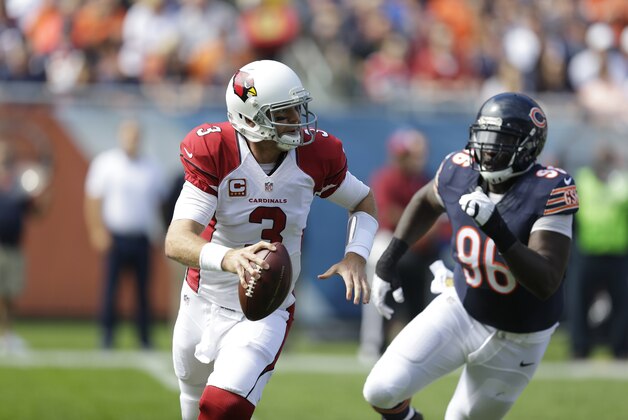 Arizona Cardinals quarterback Carson Palmer (3) scrambles away from Chicago Bears defensive tackle Jarvis Jenkins (96) during the first half of an NFL football game, Sunday, Sept. 20, 2015, in Chicago. (AP Photo/Michael Conroy)