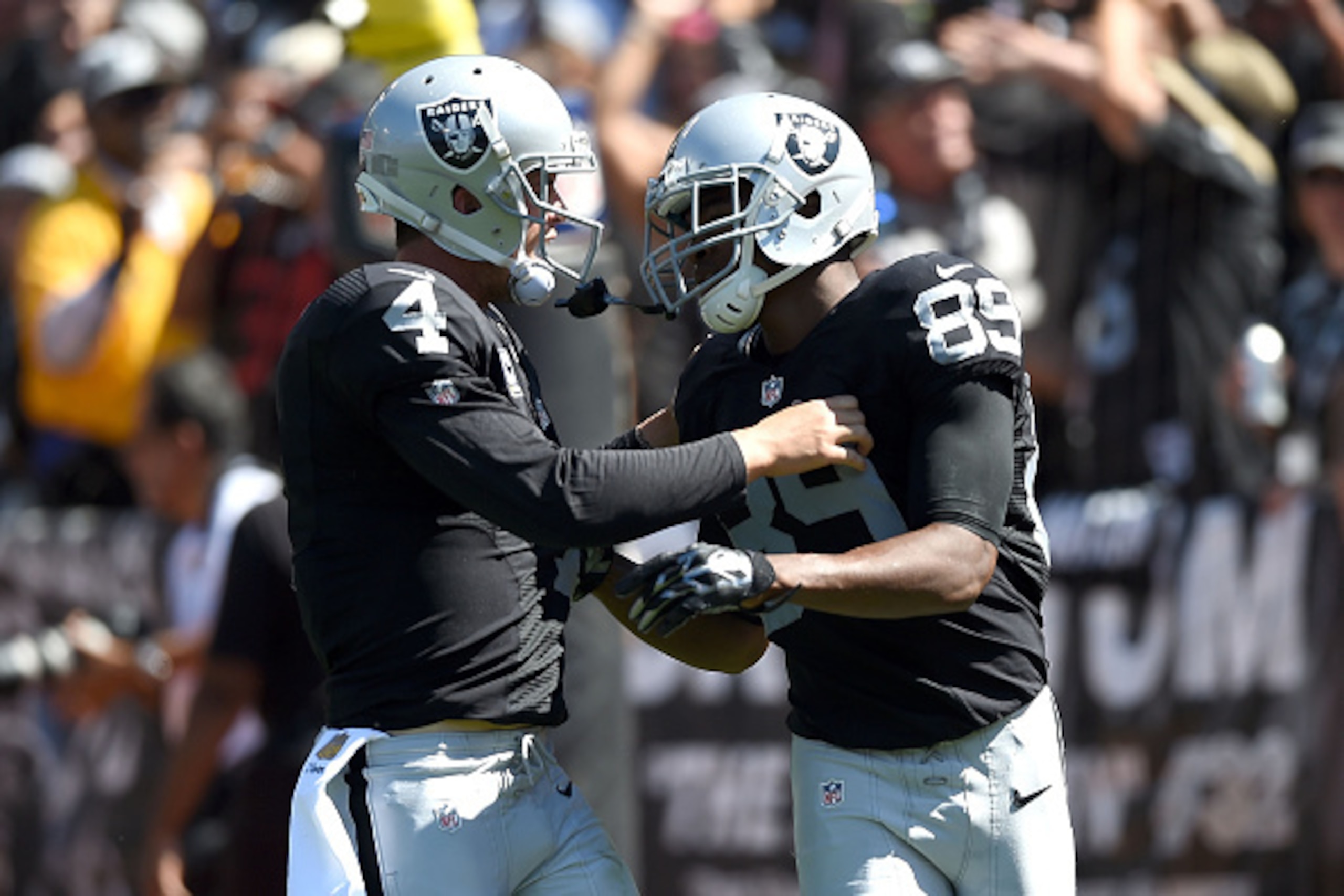 OAKLAND, CA - SEPTEMBER 20:  Derek Carr #4 of the Oakland Raiders celebrates a touchdown with Amari Cooper #89 of the Oakland Raiders in the first quarter against the Baltimore Ravens at Oakland-Alameda County Coliseum on September 20, 2015 in Oakland, California.  (Photo by Thearon W. Henderson/Getty Images)