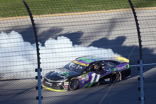JOLIET, IL - SEPTEMBER 20:  Denny Hamlin, driver of the #11 FedEx Ground Toyota, celebrates with a burnout after winning the NASCAR Sprint Cup Series myAFibRisk.com 400 at Chicagoland Speedway on September 20, 2015 in Joliet, Illinois.  (Photo by Matt Sullivan/Getty Images)