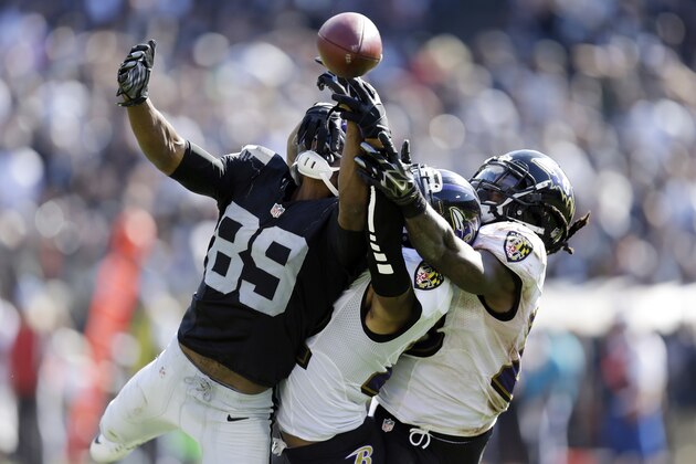 Oakland Raiders wide receiver Amari Cooper, left, loses sight of the ball for an incomplete pass as Baltimore Ravens' Jimmy Smith, center, and Kendrick Lewis defends during the second half of an NFL football game Sunday, Sept. 20, 2015, in Oakland , Calif. (AP Photo/Ben Margot)