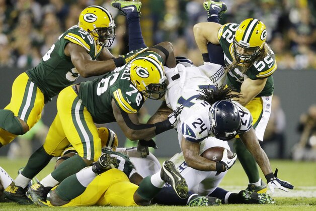 Seattle Seahawks' Marshawn Lynch is stopped by Green Bay Packers' Clay Matthews (52), Mike Daniels (76) and Andy Mulumba (55) during the first half of an NFL football game Sunday, Sept. 20, 2015, in Green Bay, Wis. (AP Photo/Jeffrey Phelps)