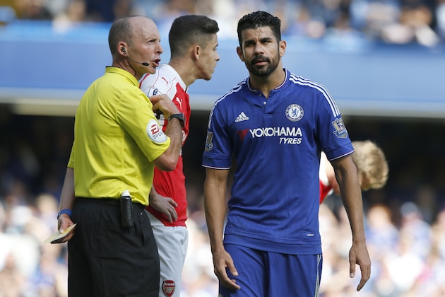 Referee Michael Dean holds a yellow cards after booking both Chelsea's Diego Costa, right, and Arsenal's Gabriel during the English Premier League soccer match between Chelsea and Arsenal at Stamford Bridge stadium in London, Saturday, Sept. 19 2015. Arsenal's Gabriel was sent off moments later for a further clash with Costa .(AP Photo/Alastair Grant)