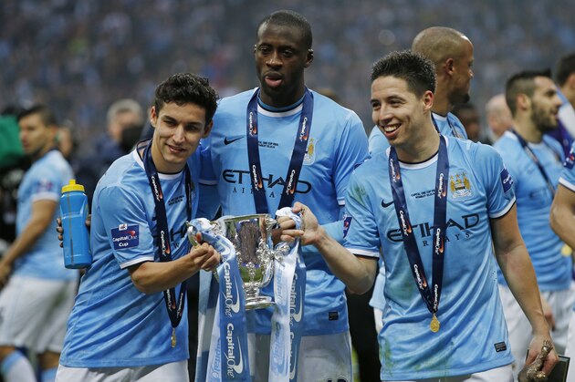 Manchester City's Spanish midfielder Jesus Navas (L), Manchester City's Ivorian midfielder Yaya Toure (C) and Manchester City's French midfielder Samir Nasri (R) pose with the League Cup after Manchester City won the League Cup final football match against Sunderland at Wembley Stadium in London on March 2, 2014. Manchester City won 3-1.  AFP PHOTO / ADRIAN DENNIS

RESTRICTED TO EDITORIAL USE. No use with unauthorized audio, video, data, fixture lists, club/league logos or live services. Online in-match use limited to 45 images, no video emulation. No use in betting, games or single club/league/player publications        (Photo credit should read ADRIAN DENNIS/AFP/Getty Images)