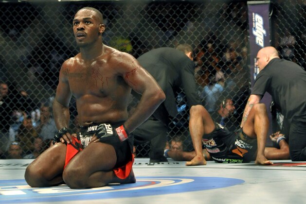 Jon Jones, left, of Endicott, N.Y., kneels in the center of the rink after knocking out Rampage Jackson, right, of Irvine, Calif., during the fourth round of their UFC Light Heavyweight title bout, Saturday, Sept. 24, 2011, in Denver. Jones won the fight with a knockout in the fourth round. (AP Photo/ Jack Dempsey )