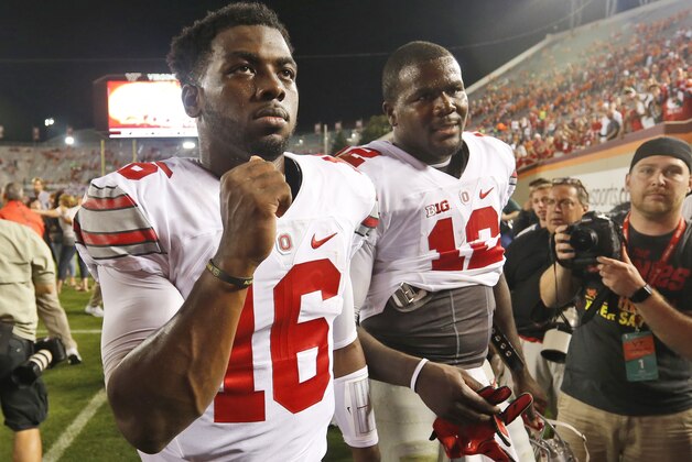 Ohio State quarterback J.T. Barrett (16) and teammate quarterback Cardale Jones (12) celebrate winning over Virginia Tech after an NCAA college football game in Blacksburg, Va., Monday, Sept. 7, 2015.  Ohio State won the game 42-24.  (AP Photo/Steve Helber)