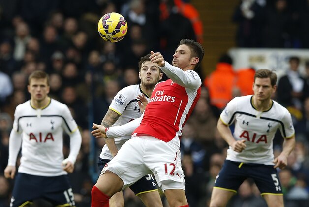 Arsenal's Olivier Giroud controls the ball as Spurs players look on during the English Premier League soccer match between Tottenham Hotspur and Arsenal at the White Hart Lane stadium in London, Saturday, Feb. 7, 2015. (AP Photo/Alastair Grant)