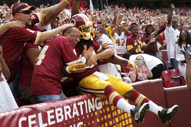 Washington Redskins running back Matt Jones jumps into the fans after scoring a touchdown during the first half of an NFL football game against the St. Louis Rams in Landover, Md., Sunday, Sept. 20, 2015. (AP Photo/Alex Brandon)