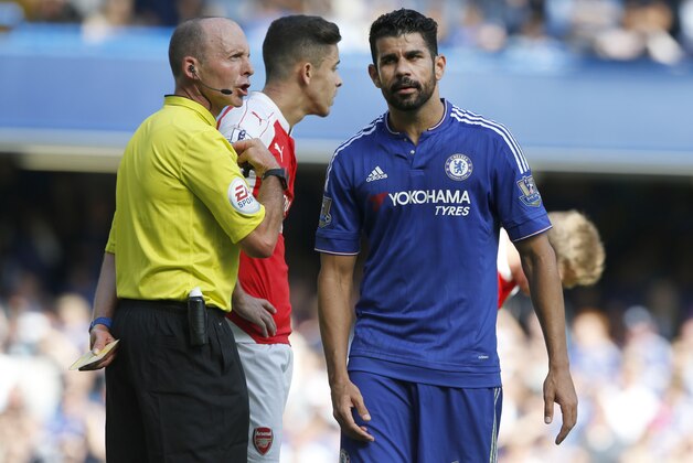 Referee Michael Dean holds a yellow cards after booking both Chelsea's Diego Costa, right, and Arsenal's Gabriel during the English Premier League soccer match between Chelsea and Arsenal at Stamford Bridge stadium in London, Saturday, Sept. 19 2015. Arsenal's Gabriel was sent off moments later for a further clash with Costa .(AP Photo/Alastair Grant)