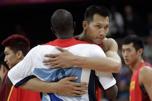 China's Yi Jianlian, right, hugs Britain's Luol Deng, left, after their preliminary men's basketball game at the 2012 Summer Olympics, Monday, Aug. 6, 2012, in London. (AP Photo/Eric Gay)
