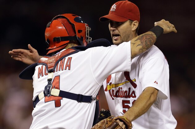 St. Louis Cardinals starting pitcher Adam Wainwright, right, gets a hug from catcher Yadier Molina after throwing a complete baseball game against the Milwaukee Brewers, Wednesday, Sept. 17, 2014, in St. Louis. The Cardinals won 2-0. (AP Photo/Jeff Roberson)