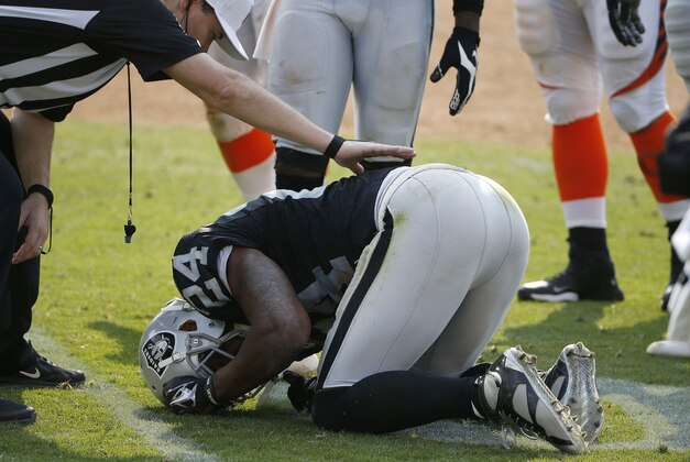 Oakland Raiders cornerback Charles Woodson (24) lays on the ground after being injured during the second half of an NFL football game against the Cincinnati Bengals in Oakland, Calif., Sunday, Sept. 13, 2015. (AP Photo/Tony Avelar)