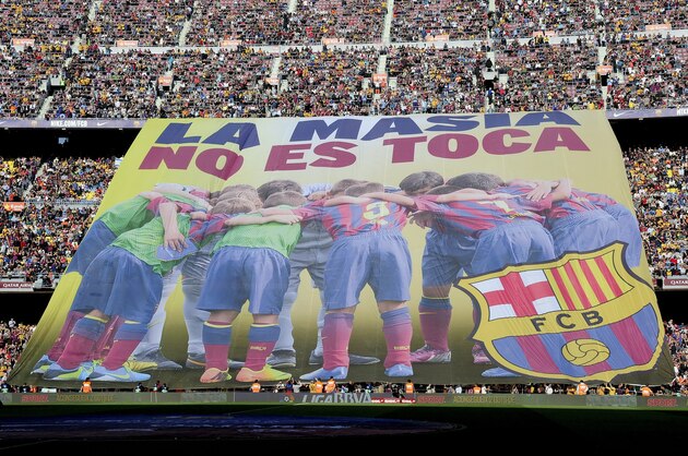 Barcelona's supporters unveil a giant banner reading in Catalan 'La Masia, don't touch it' before the Spanish league football match FC Barcelona vs Real Betis at the Camp Nou stadium in Barcelona.  AFP PHOTO / JOSEP LAGO        (Photo credit should read JOSEP LAGO/AFP/Getty Images)