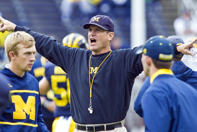 Michigan head coach Jim Harbaugh directs his players during warmups before an NCAA college football game against UNLV in Ann Arbor, Mich., Saturday, Sept. 19, 2015. (AP Photo/Tony Ding)