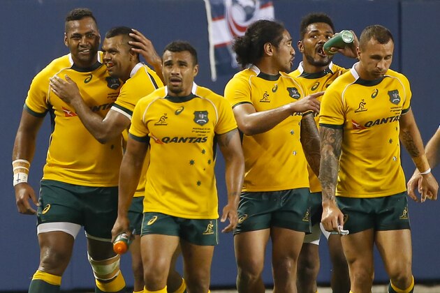 Australia's Taqele Naiyaravor, left, celebrates with teammates after scoring against the United States during the second half of an international rugby test match at Soldier Field, Saturday, Sept.5, 2015, in Chicago. Australia won 47-10. (AP Photo/Kamil Krzaczynski)