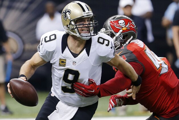 FILE - In this Sept. 20, 2015 file photo, New Orleans Saints quarterback Drew Brees (9) scrambles under pressure from Tampa Bay Buccaneers defensive end George Johnson (94) in the first half of an NFL football game in New Orleans.  The Saints have fallen to 0-2 because of a mistake-filled performance that drew boos from fans in the Superdome. Be it penalties, turnovers, blown assignments, special teams slip-ups or substitution problems, coach Sean Payton has a lot to address before a tough Week 3 contest at Carolina.  (AP Photo/Bill Haber)
