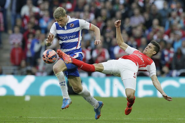 Reading’s Pavel Pogrebnyak, left, competes for the ball with Arsenal’s Gabriel Paulista during the English FA Cup semifinal soccer match between Arsenal and Reading at Wembley Stadium in London, Saturday, April 18, 2015. (AP Photo/Tim Ireland)