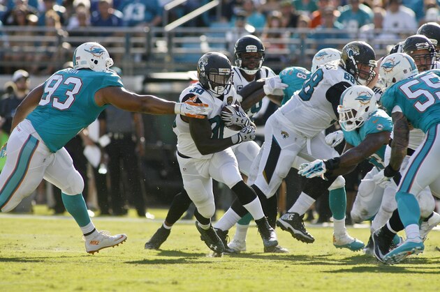 Sep 20, 2015; Jacksonville, FL, USA; Jacksonville Jaguars running back Bernard Pierce (30) gets past Miami Dolphins defensive tackle Ndamukong Suh (93) in the second quarter at EverBank Field. Mandatory Credit: Phil Sears-USA TODAY Sports