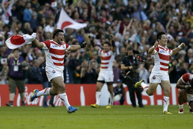 Japan players celebrate defeating South Africa 32-34 in the Rugby World Cup Pool B match at the Brighton Community Stadium, Brighton, England Saturday, Sept. 19, 2015. (AP Photo/Tim Ireland)
