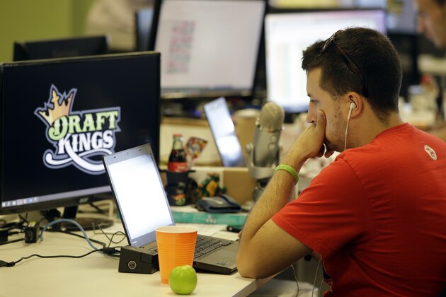 In this Wednesday, Sept. 9, 2015, photo, Devlin D'Zmura, a tending news manager at DraftKings, a daily fantasy sports company, works on his laptop at the company's offices in Boston. The daily fantasy sports industry is eyeing a breakout season as NFL games begin. And its two dominant companies, DraftKings and FanDuel, are touting lucrative opening week prizes to try to draw more customers as more competitors pop up. (AP Photo/Stephan Savoia)