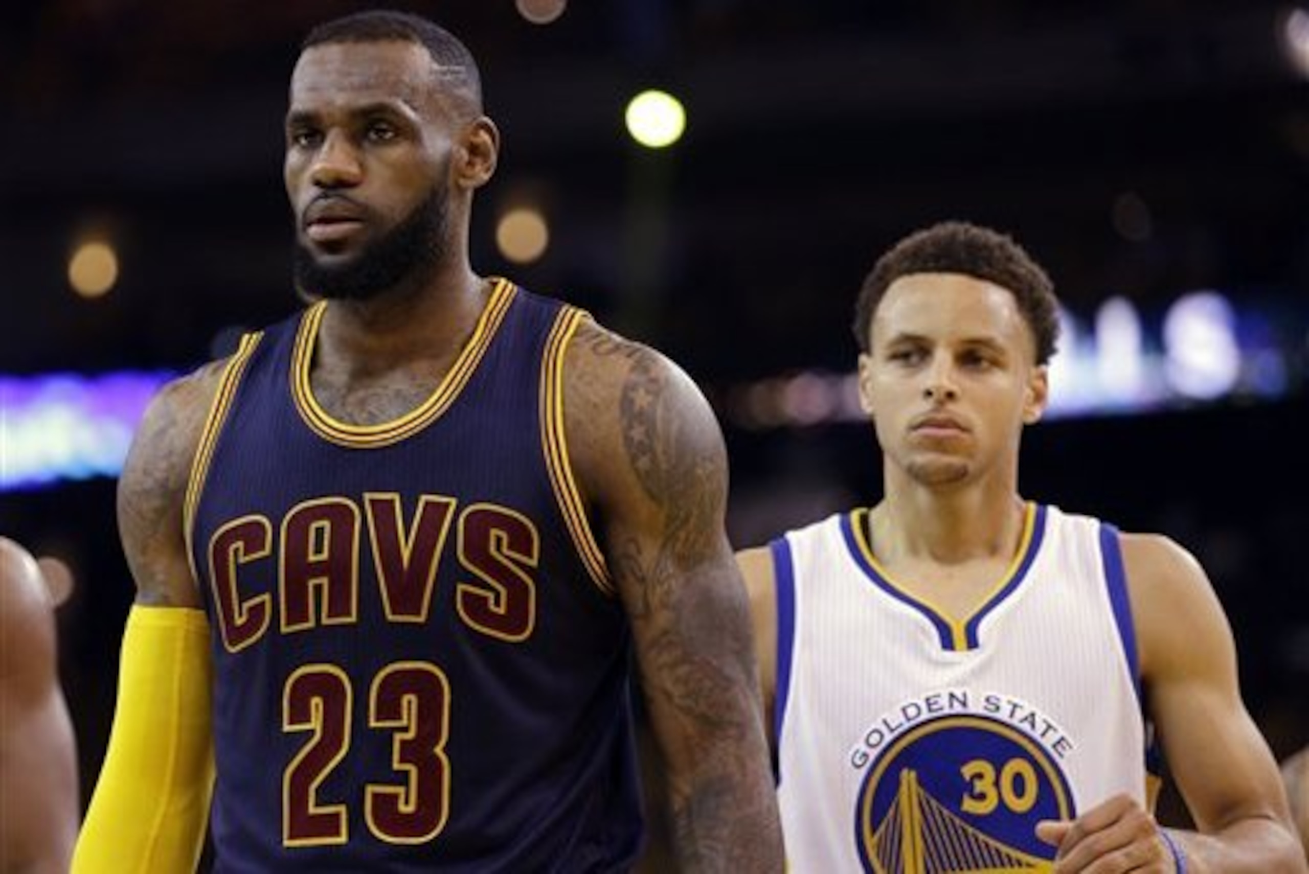 Cleveland Cavaliers forward LeBron James (23) walks in front of Golden State Warriors guard Stephen Curry (30) during the first half of Game 5 of basketball's NBA Finals in Oakland, Calif., Sunday, June 14, 2015. (AP Photo/Ben Margot)