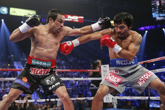 Juan Manuel Marquez, left, exchanges punches with Manny Pacquiao during their WBO world welterweight  fight Saturday, Dec. 8, 2012, in Las Vegas. (AP Photo/Eric Jamison)