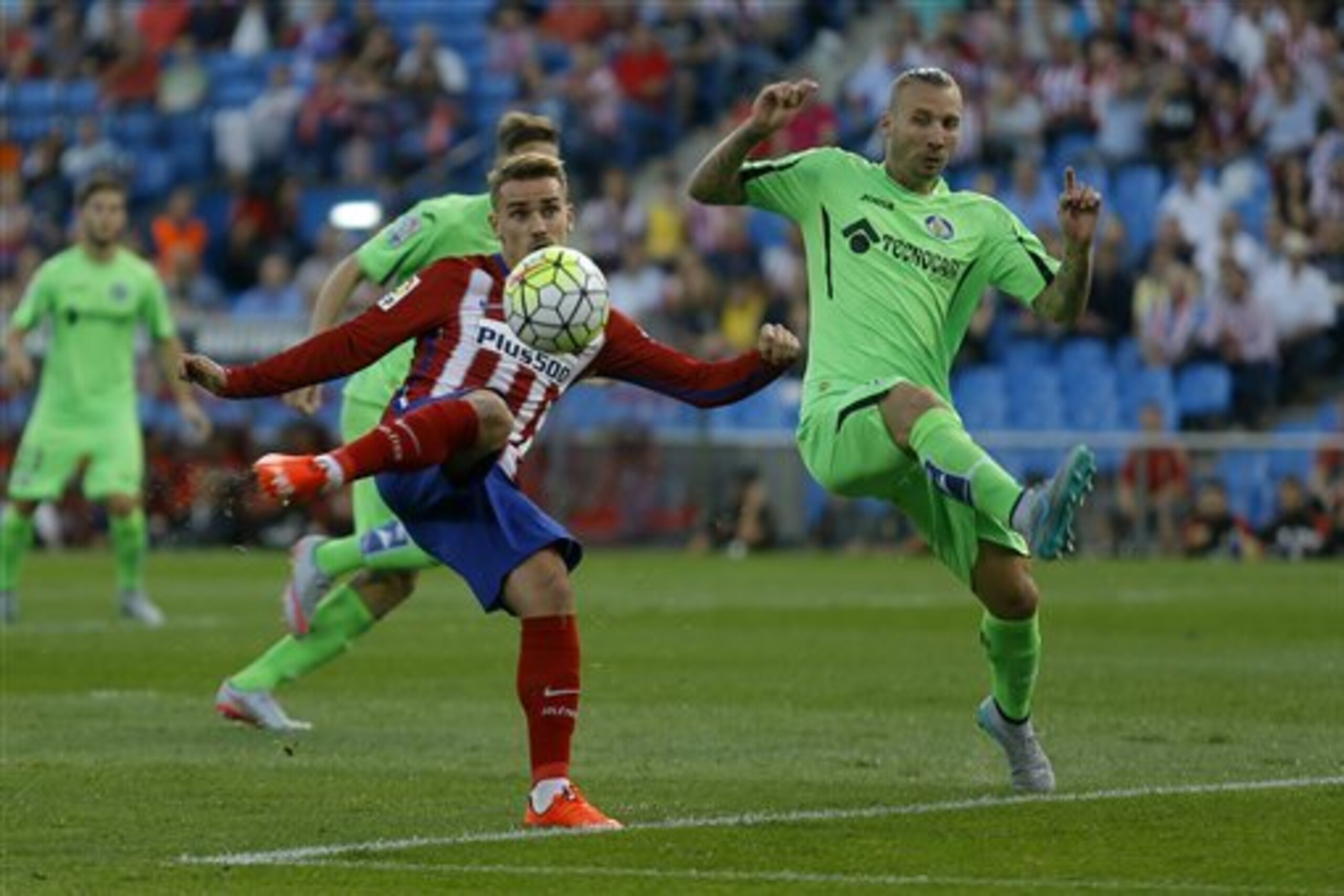 Atletico Madrid's Antoine Griezmann, left, shoots the ball to score past Getafe's Alexis Ruano during a Spanish La Liga soccer match between Atletico Madrid and Getafe at the Vicente Calderon stadium in Madrid, Tuesday, Sept. 22, 2015. (AP Photo/Francisco Seco)